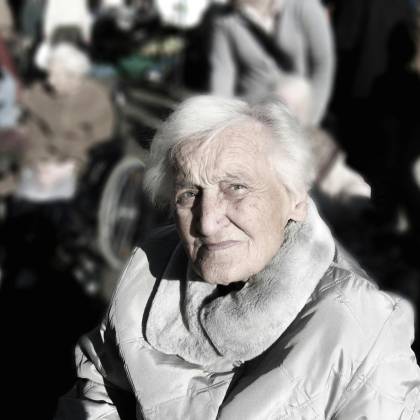 Portrait Of An Elderly Woman In A Winter Coat. Outdoor Setting With A Blurred Background.