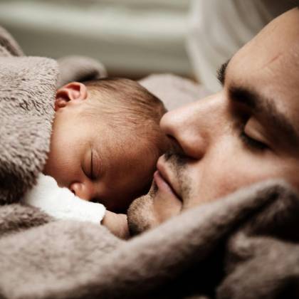 A Touching Close Up Of A Father And His Baby Peacefully Napping Together.