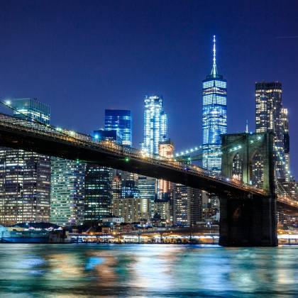 Stunning View Of The Brooklyn Bridge And New York City Skyline Illuminated At Night.