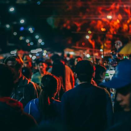 A Bustling Street Market At Night With Crowds And Vibrant Streetlights.