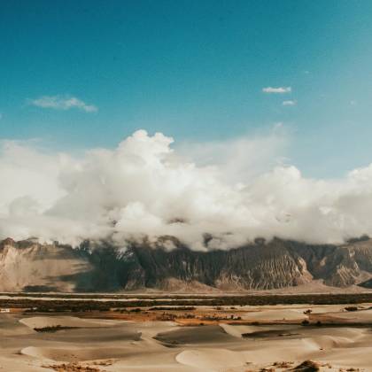 Explore The Captivating Sand Dunes And Towering Mountains Under A Vivid Blue Sky In Leh, India.