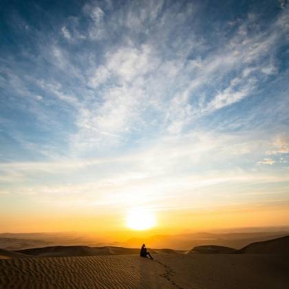 A Stunning Sunset Over Desert Dunes In Paracas, Peru, With A Solitary Silhouette Capturing Tranquility.