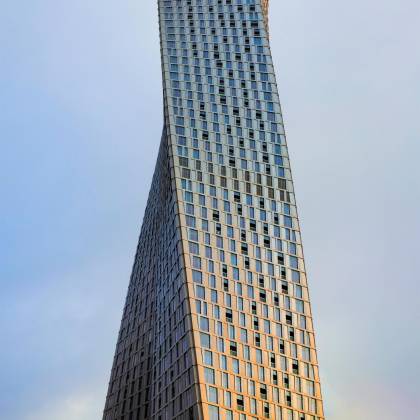 The Iconic Cayan Tower's Twisting Design Set Against A Serene Dubai Sky.