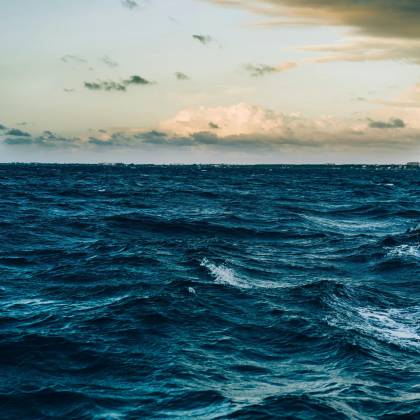 A Captivating View Of Ocean Waves Under A Dramatic Twilight Sky, Offering A Peaceful Seascape.