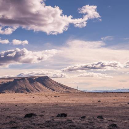 Serene View Of A Dry, Mountainous Landscape Under A Cloudy Sky.