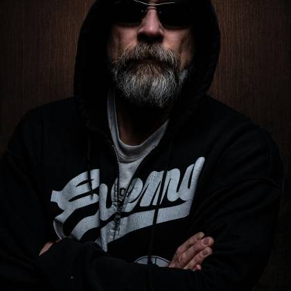 Portrait Of A Bearded Man In A Dark Hoodie And Sunglasses, Exuding Mystery.