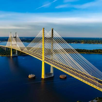 Stunning Aerial Shot Of The Dames Point Bridge Spanning Over Blue Waters Under A Clear Sky.