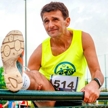 Senior Man Stretches Before Outdoor Track Run. Bright Day For Fitness.