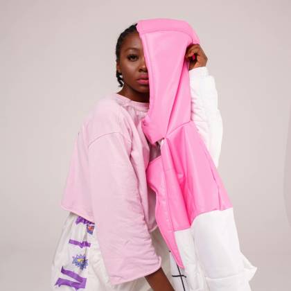 Stylish Studio Shoot Featuring A Black Model Posing In Vibrant Streetwear With A Pink Jacket.