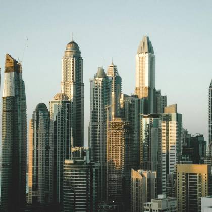 A Stunning View Of The Modern Dubai Skyline With Towering Skyscrapers Under A Clear Sky Captured During The Day.