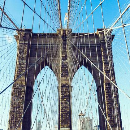 View Of The Iconic Brooklyn Bridge Showcasing Its Architecture Under A Clear Blue Sky In New York City.