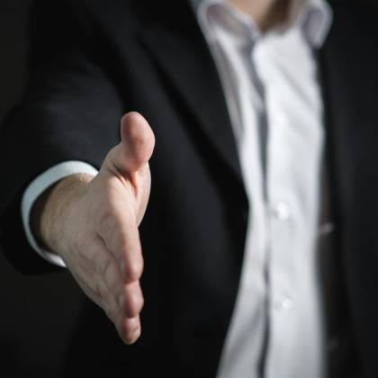 Close Up Of A Businessman Extending Hand For A Handshake, Symbolizing Agreement And Partnership.