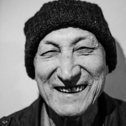 A Close Up Black And White Portrait Of An Elderly Man Joyfully Smiling.