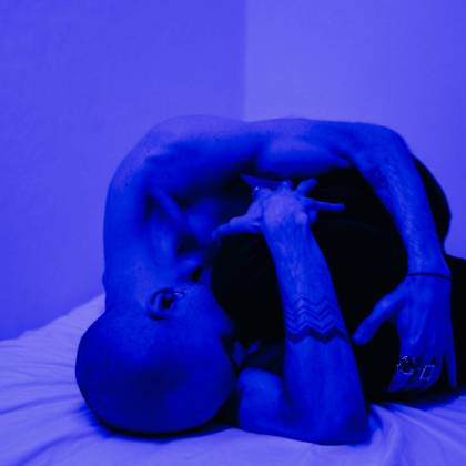 A Man Expressing Deep Emotion And Solitude Under Blue Lighting, Highlighting Mental Health Themes.