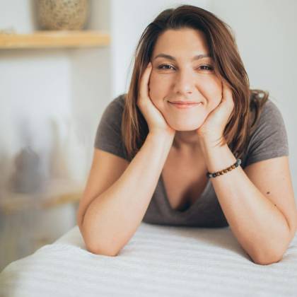 Woman Smiling Indoors, Enjoying A Relaxing Spa Day With A Happy Expression.