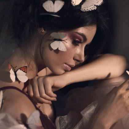 Artistic Portrait Of A Woman With Closed Eyes And Butterflies, Showcasing Elegance In A Studio Setting.