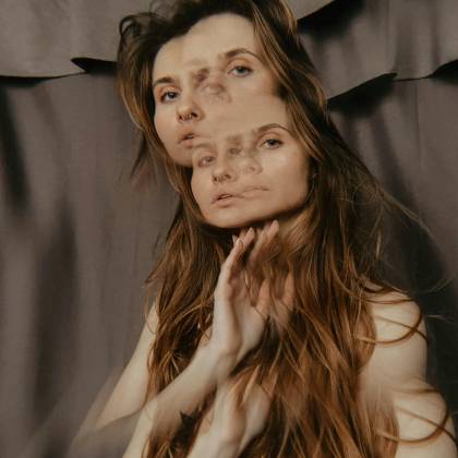 A Creative Double Exposure Portrait Of A Woman With Long Brown Hair And A Blurred Abstract Appearance.