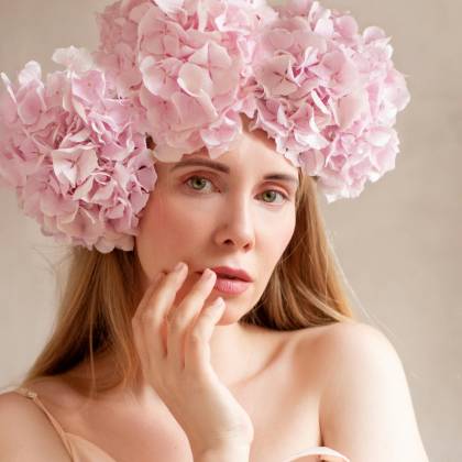 A Stunning Studio Portrait Of A Woman Wearing A Pink Hydrangea Flower Headdress.
