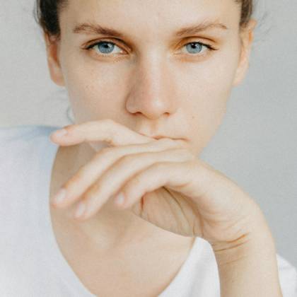 Close Up Portrait Of A Woman With Blue Eyes, Looking Thoughtful And Serene.