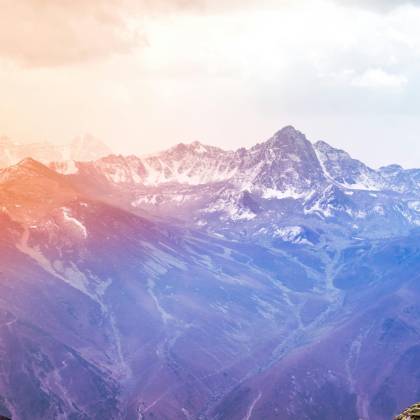 Breathtaking View Of Snow Covered Mountains At Sunrise With A Vibrant Sky.
