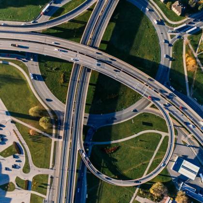 Aerial Photograph Of A Complex Highway Interchange, Capturing Dynamic City Traffic.