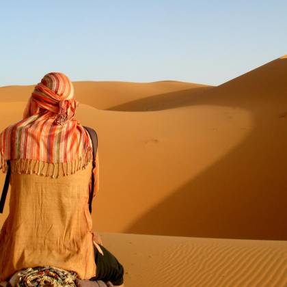 Traveler Viewed From Behind, Admiring Morocco's Striking Sand Dunes.