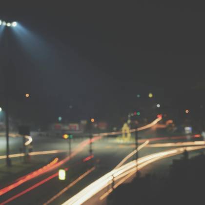 Blurred Long Exposure Photo Capturing Light Trails At An Urban Intersection At Night.