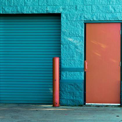 Vivid Blue Wall With A Closed Door And Shutter In Valparaiso's Urban Setting.
