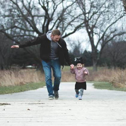 Dad And Daughter Enjoying A Walk In The Park, Symbolizing Love And Togetherness.