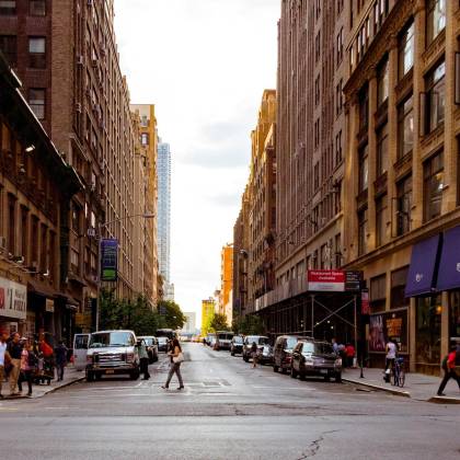 Lively Urban Street In New York City With Pedestrians And Vehicles On A Sunny Day.